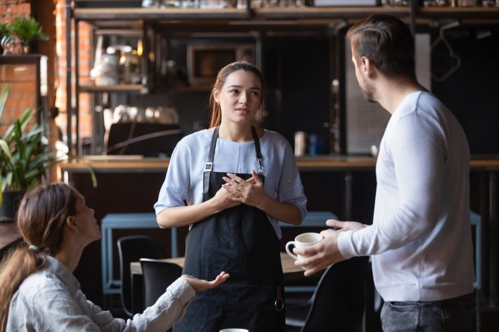 A waitress seemingly in an argument with a restaurant guest. 